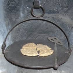 Quartered oat cake on metal gridiron with spade